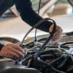 A mechanic is shown replacing a timing belt.
