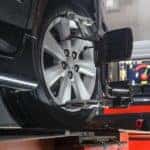 A car is shown having an alignment performed.