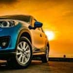 A car is shown parked under the sun.