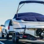 An SUV is shown towing a boat.