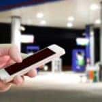 A cellphone is shown being used at a gas station.