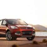 A red 2017 Ford Escape is shown parked next to a lake.