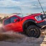 A Ford F-150 Raptor R is shown off-roading in the sand.
