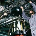 A mechanic is shown completing an oil change.