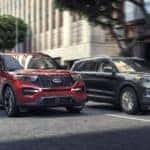 A red 2020 Ford Explorer ST is shown driving next to a grey 2020 Ford Explorer.