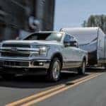 A white 2018 Ford F-150 is shown towing a trailer.