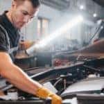 A mechanic is shown working on a vehicle.