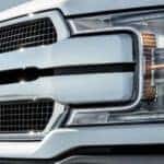 A close up shows the grille on a white 2020 Ford F-150.