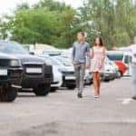 A customer is shown being helped in a used car lot.