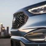 A close up shows the grille on a blue 2021 Ford Edge ST.