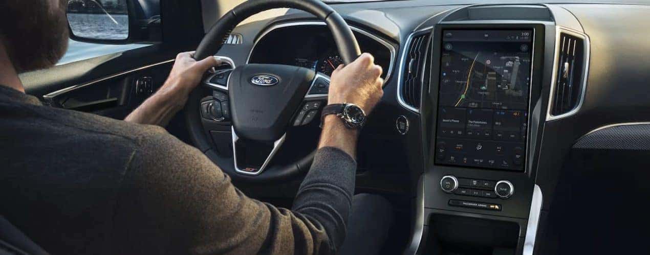 A person is shown driving a 2022 Ford Edge ST with the a map open on the infotainment screen.