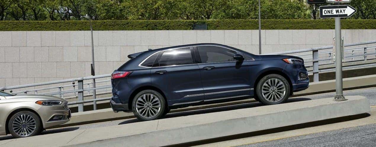 A blue 2022 Ford Edge Titanium Elite is shown from the side on a city street.