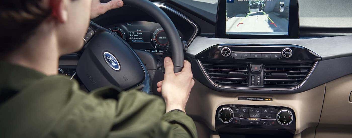 A person is shown viewing the back-up camera feature in a 2022 Ford Escape.