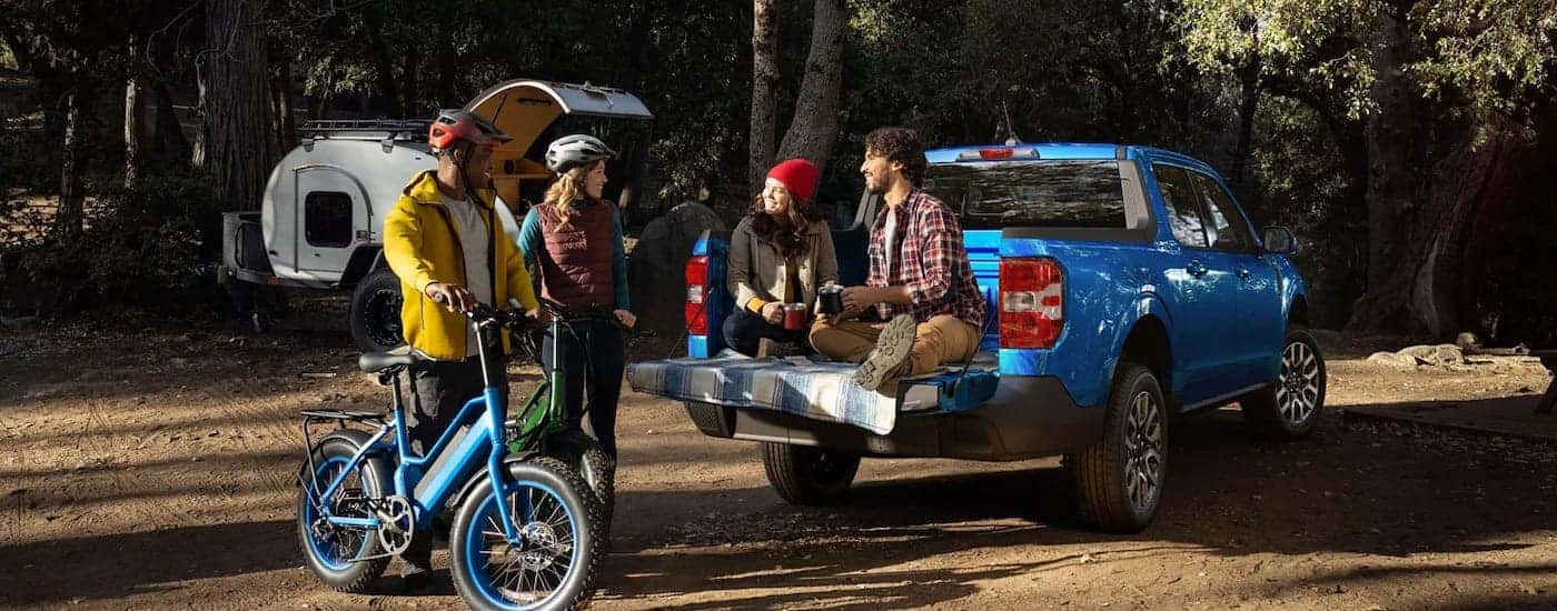 A blue 2022 Ford Maverick is shown at a camping area.