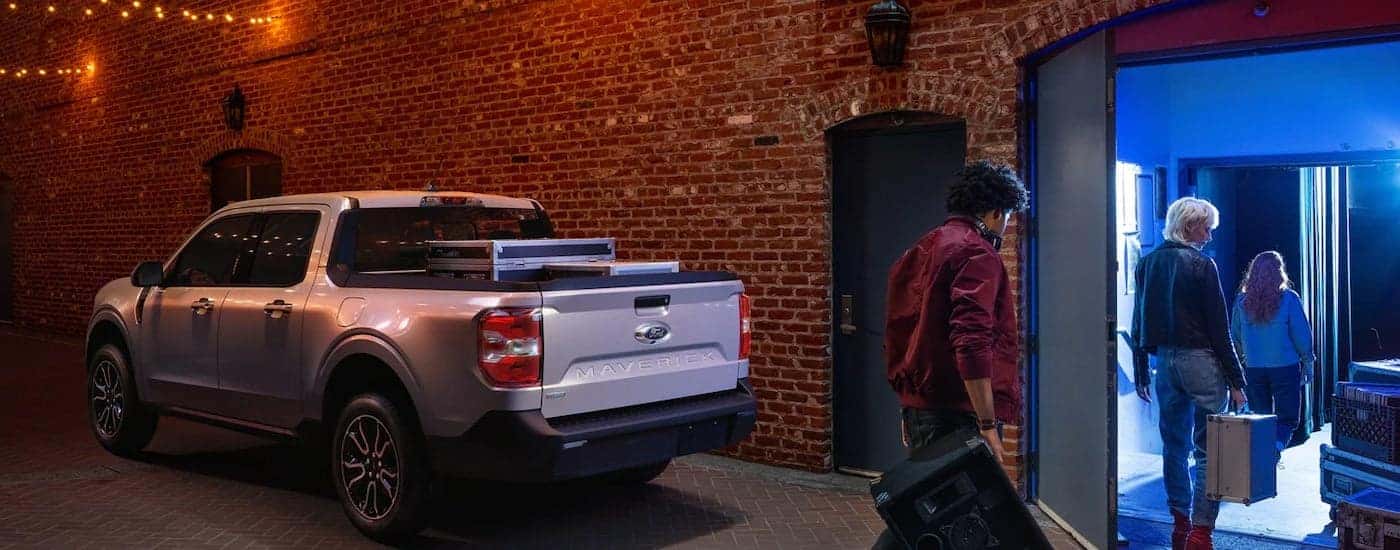 A silver 2022 Ford Maverick is shown from the rear parked outside of a brick building.