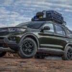 A green 2022 Ford Explorer is shown from the side in the mountains.