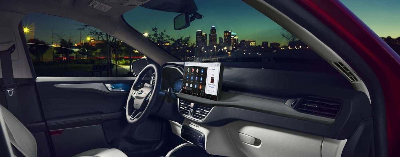 The black and grey interior of a 2023 Ford Escape shows the steering wheel and center console.