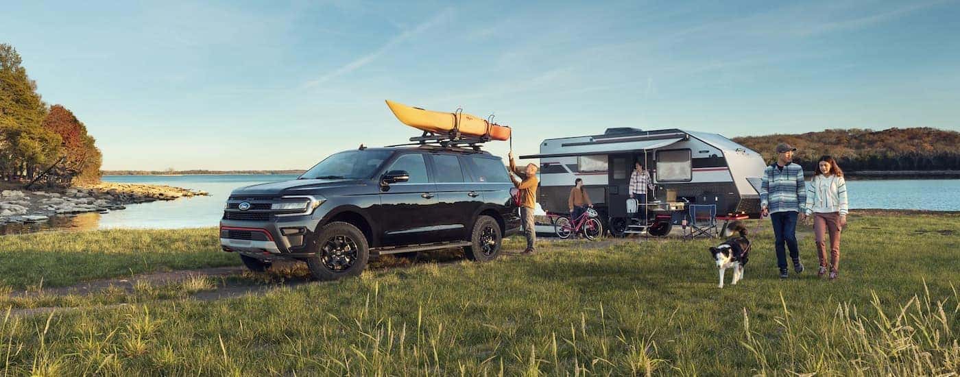 A black 2023 Ford Expedition Timberline is shown parked at a camp site.