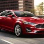 A red 2020 Ford Fusion is shown leaving a used car dealer near Noblesville.