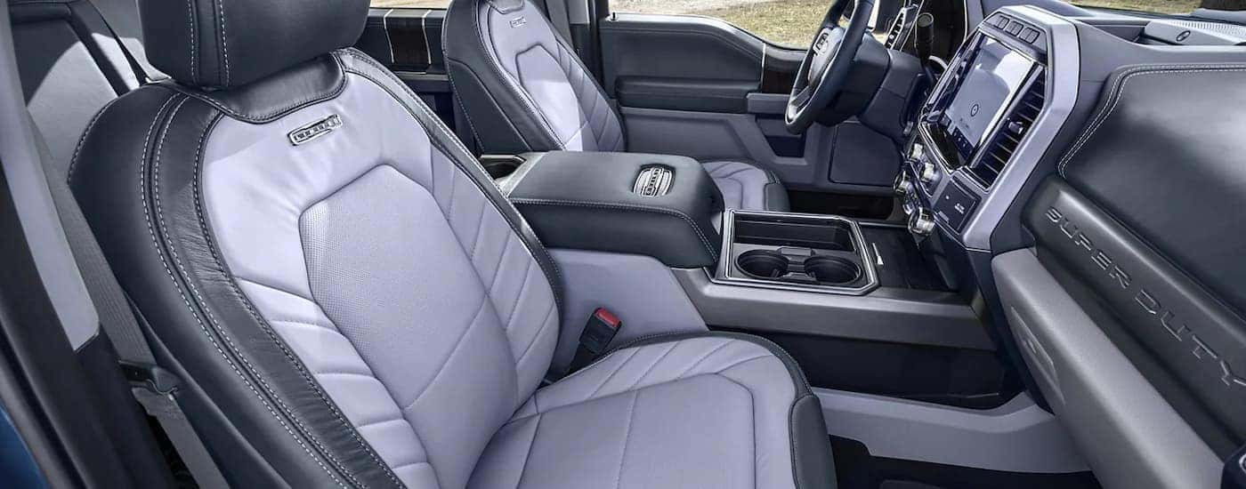 The grey interior of a 2022 Ford F-250 Limited shows the front seats and infotainment screen.