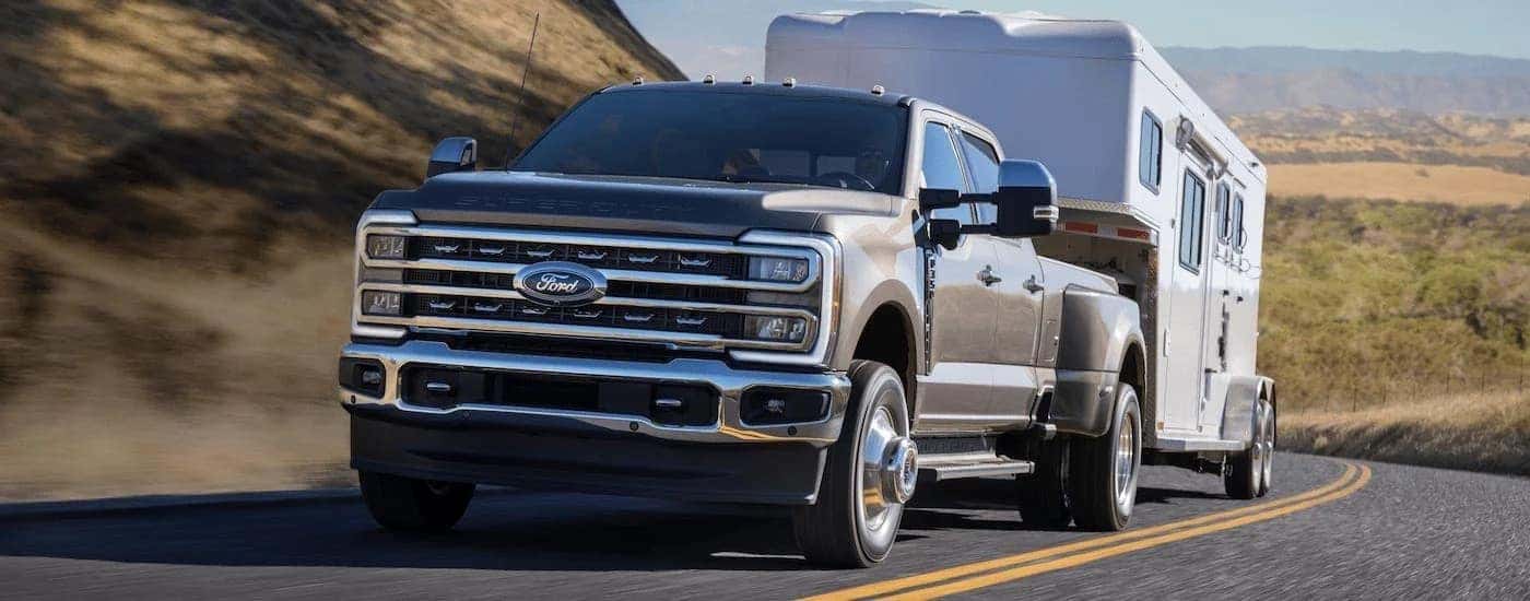A grey 2023 Ford F-350 Lariat towing a trailer.