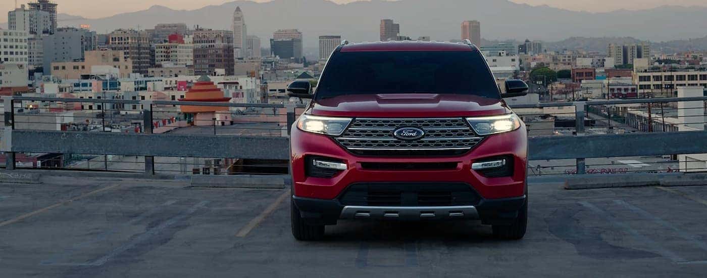 A red 2023 Ford Explorer Limited Hybrid is shown overlooking a city.