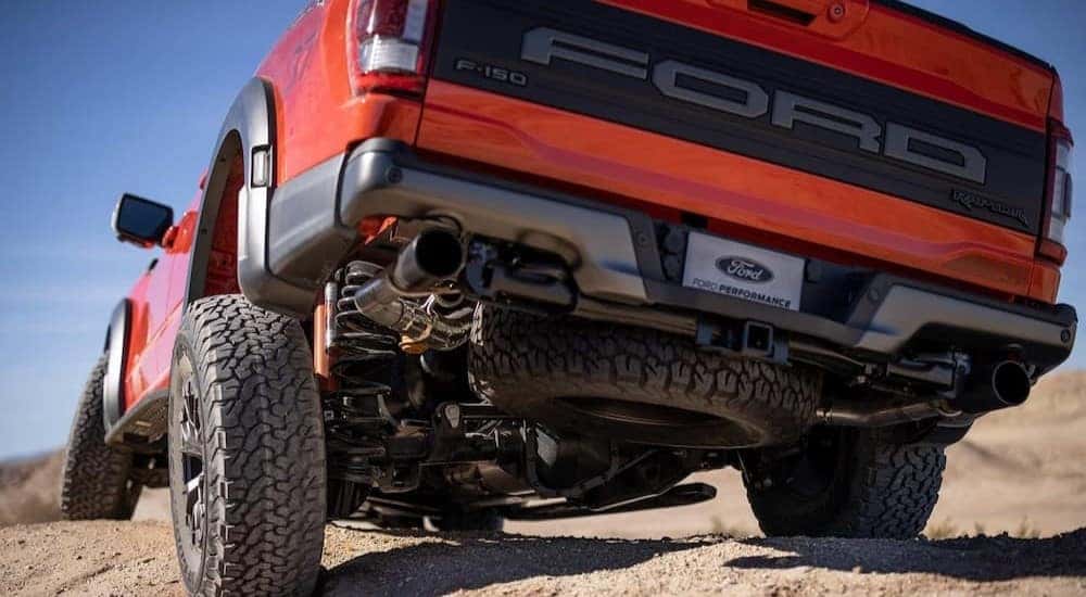 The 5 link rear suspension with a panhard rod and 24 inch coil springs are shown on a red 2023 Ford F-150 Raptor.