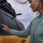 A person is shown using the keyless entry on a yellow 2021 Ford Bronco Sport Badlands after looking at used cars for sale.