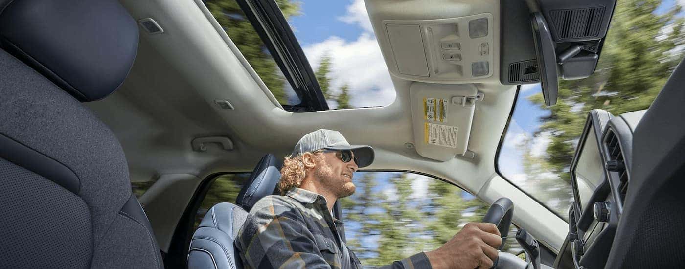 A man is shown driving in a 2022 Ford Bronco Sport for sale with the sunroof open.