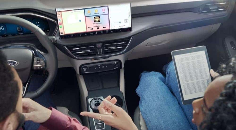 People are shown using SYNC 4 in a 2023 Ford Escape for sale.