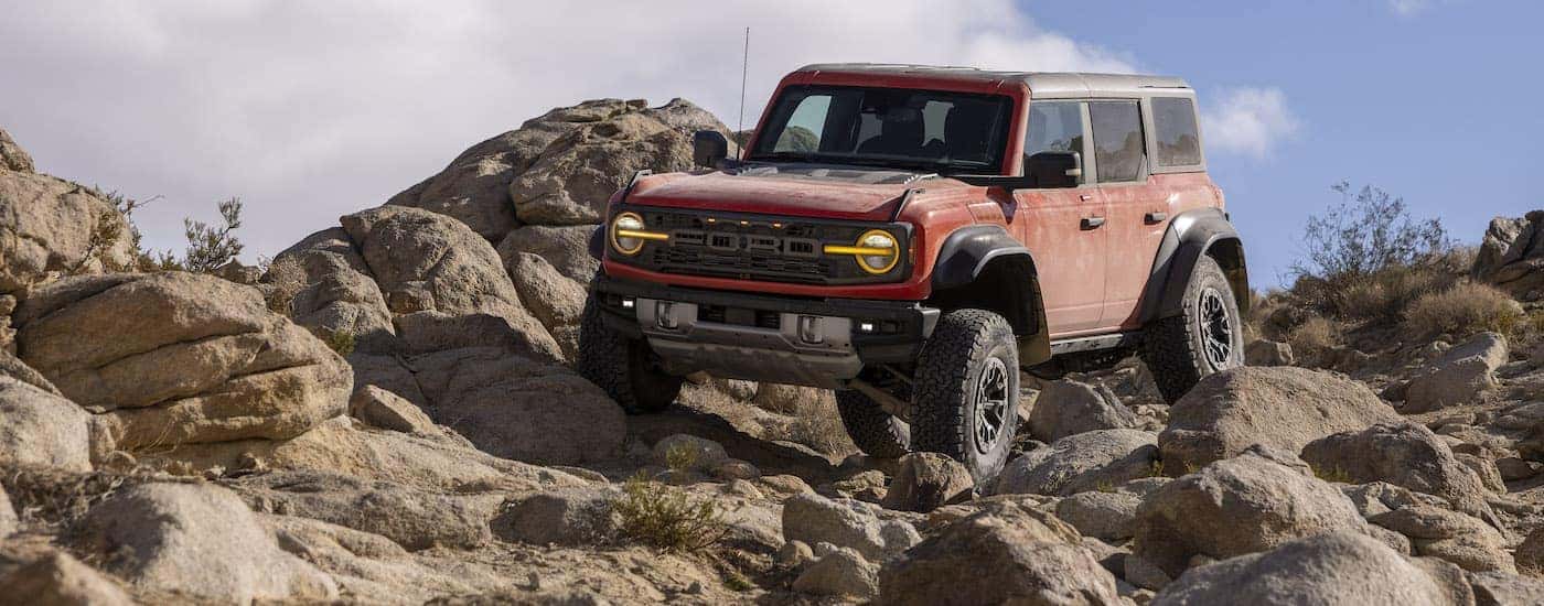 A red 2022 Ford Bronco Raptor is shown from the front at an angle.