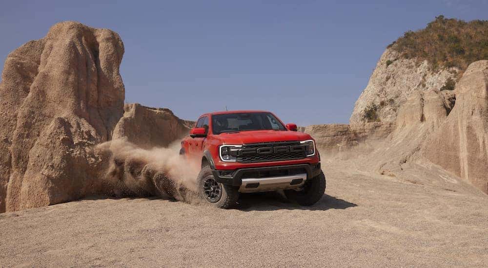 An orange 2024 Ford Ranger Raptor is shown from the front at an angle after leaving a Ford dealer near Plainfield.