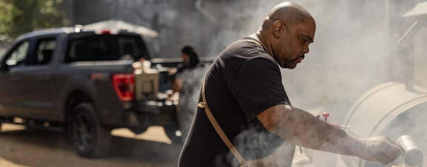 People are shown barbequing near a black 2023 Ford F-150.