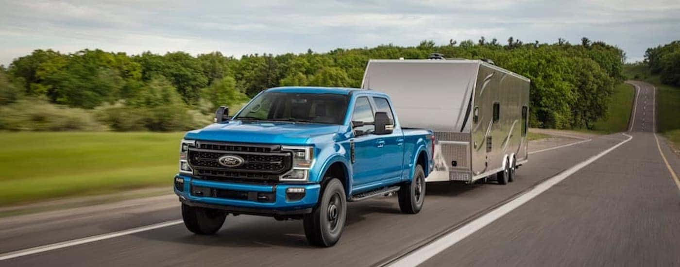 A blue 2020 Ford F-250 Tremor is shown from the front while towing a trailer.
