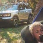 A person is shown in a hammock near a silver 2023 Ford Bronco Sport after leaving a Ford dealer near Noblesville.