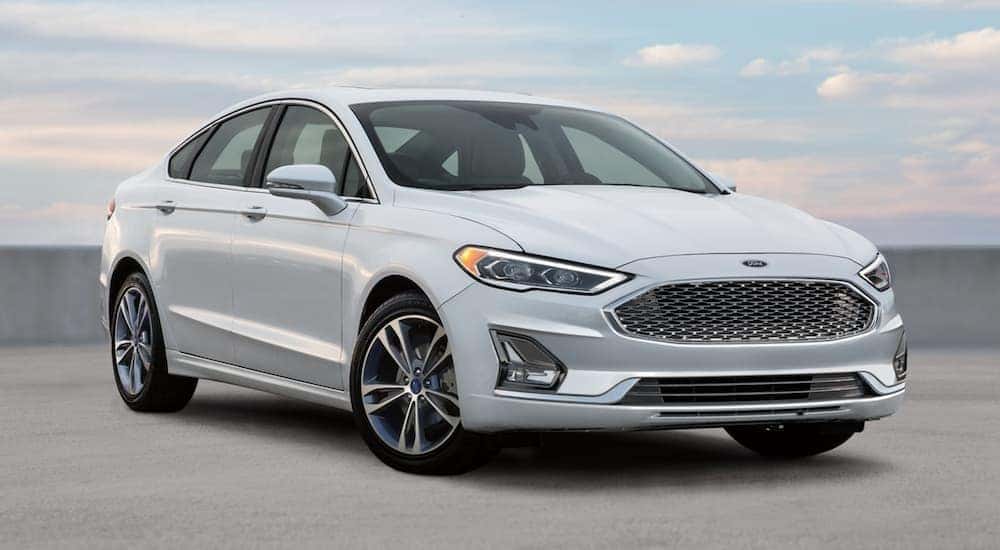 A white 2020 Ford Fusion is shown parked at a used car dealer near Indianapolis.