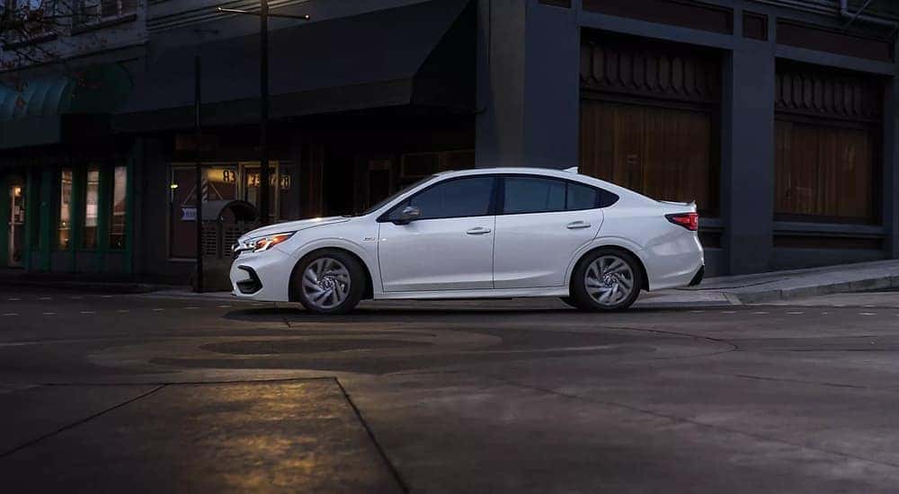 A white 2023 Subaru Legacy Sport is shown driving in a city..