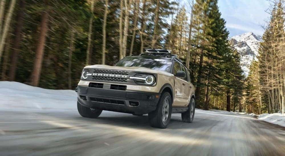 A tan 2024 Ford Bronco Sport Badlands is shown driving off-road after visiting a car dealership near Indianapolis.