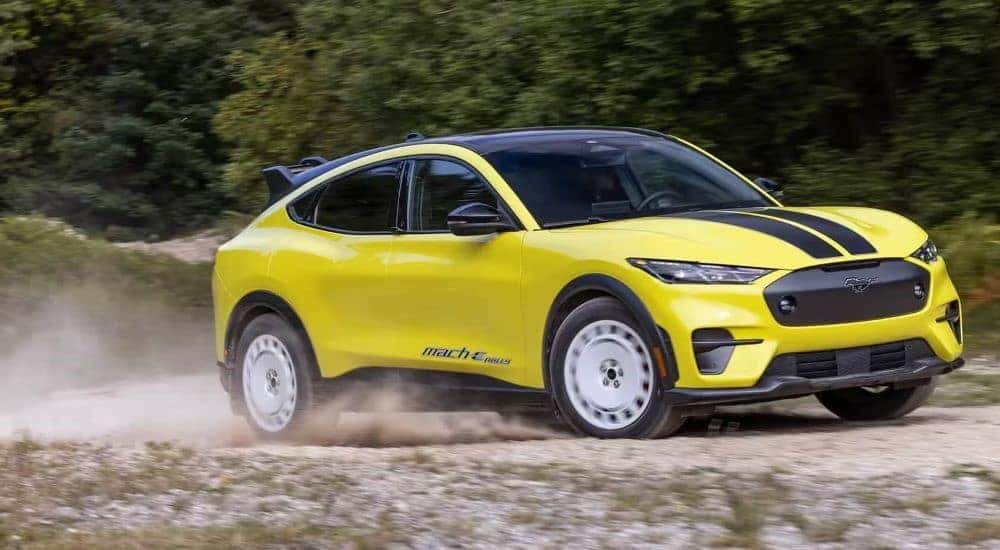 A yellow 2024 Ford Mustang Mach-E Rally Edition is shown driving off-road.