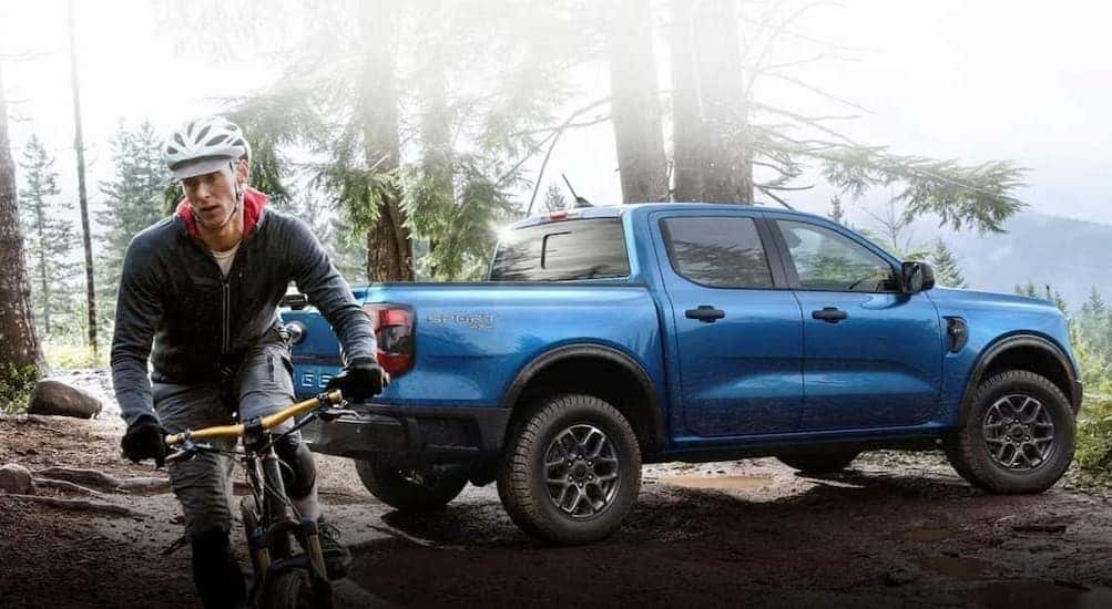 A blue 2024 Ford Ranger Sport is shown parked near a bicyclist.