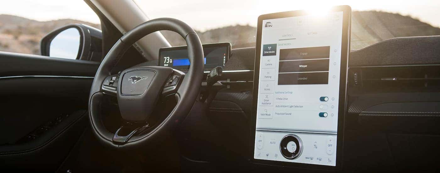 The black interior of a 2024 Ford Mustang Mach-E for sale near Carmel is shown from the passenger seat.
