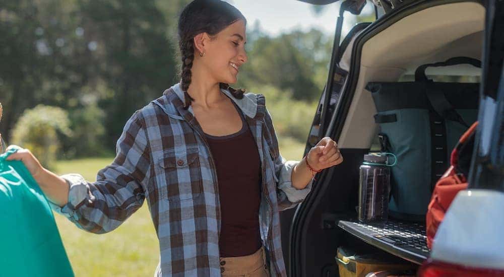 A woman is showing putting gear in the back of a 2024 Ford Bronco Sport.