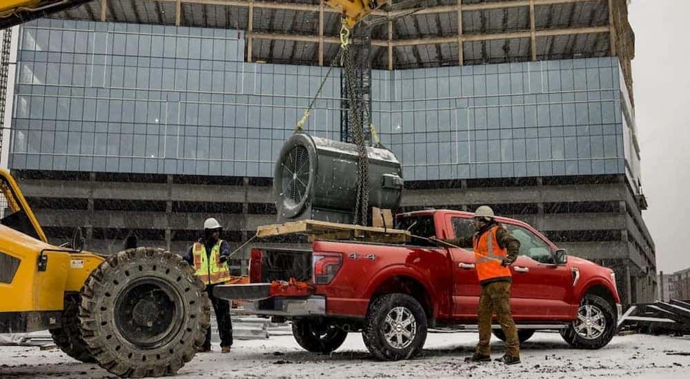 A red 2024 Ford F-150 for sale near Indianapolis is parked on a construction site.
