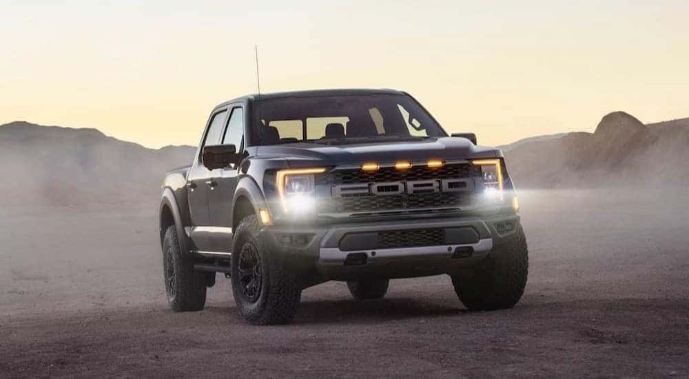 A gray 2024 Ford F-150 Raptor is shown parked off-road.