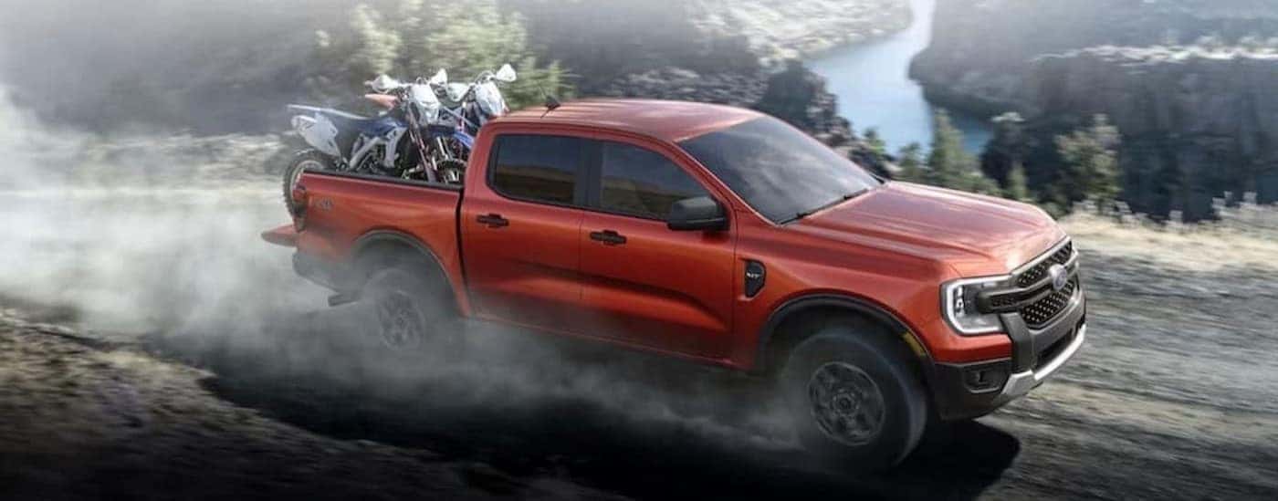 A red 2024 Ford Ranger is shown driving off-road.