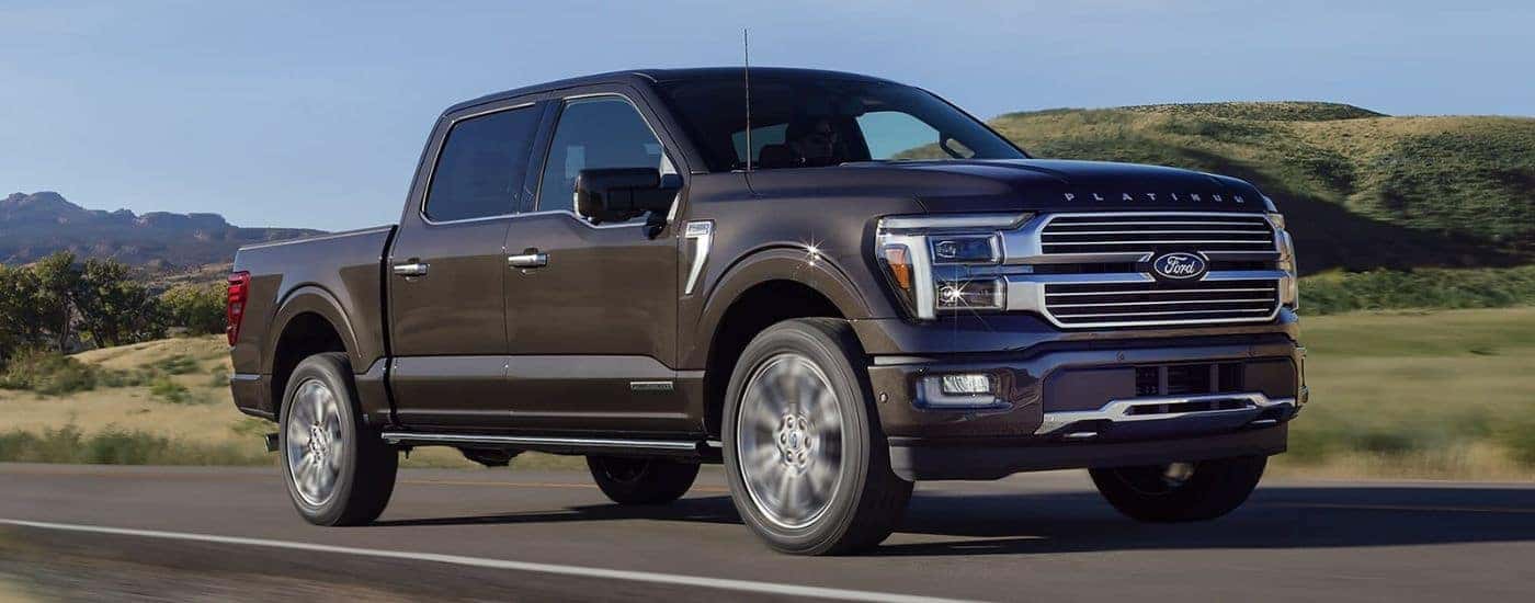 A brown 2024 Ford F-150 for sale near Indianapolis is shown driving on an open road.