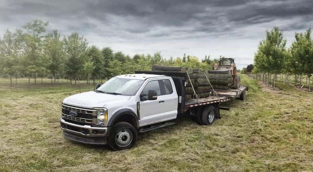 A white 2023 Ford F-450 is shown parked off-road.
