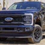 A popular Ford Super Duty for sale, a black 2024 Ford F-250, is shown parked off-road.