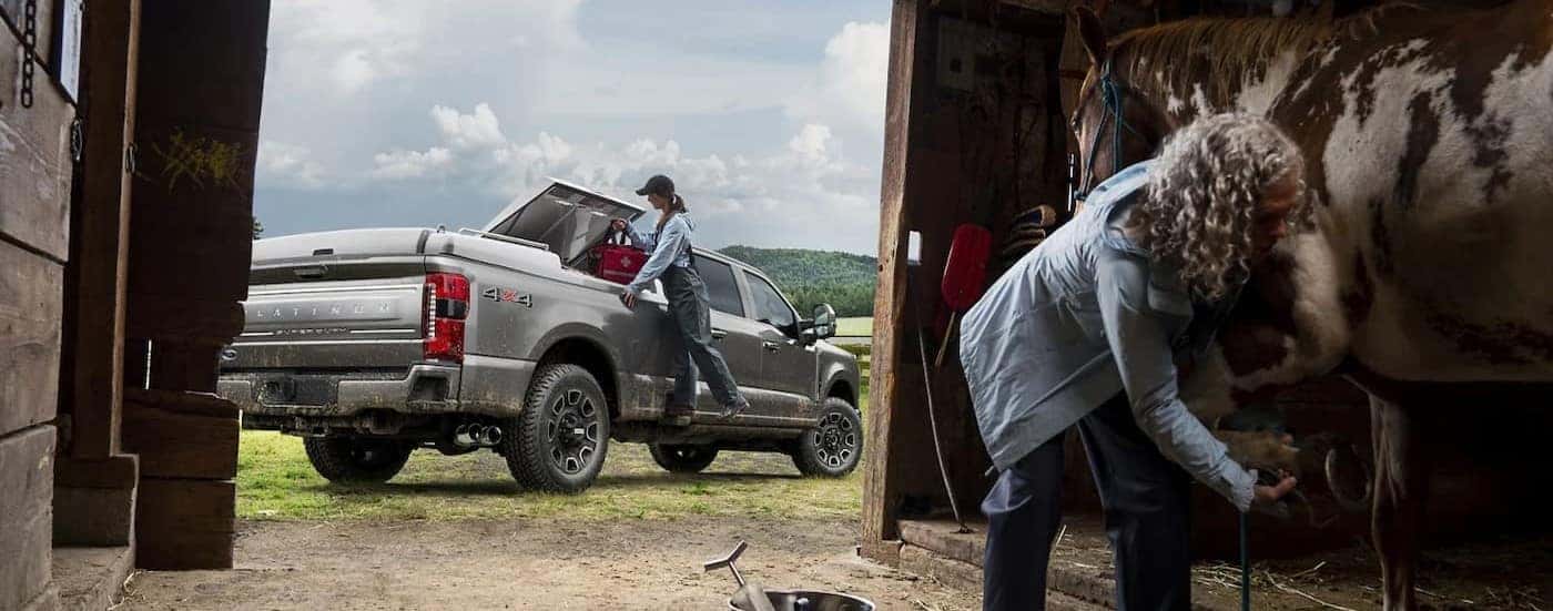 A silver 2024 Ford F-250 is shown parked near a barn.