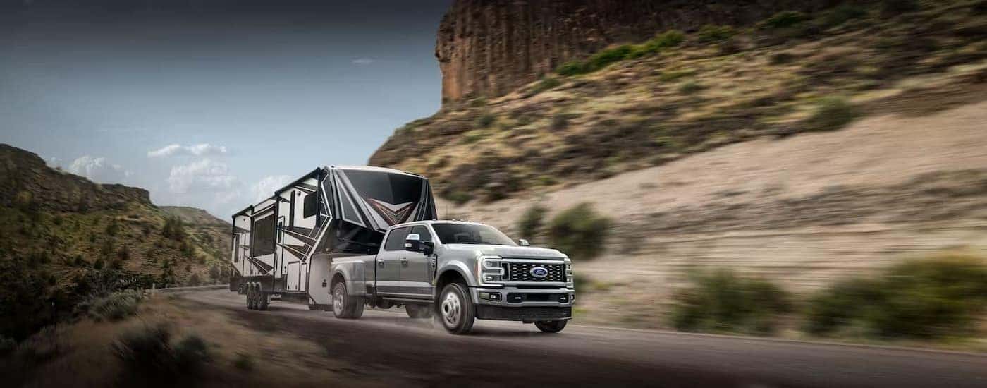 A silver 2024 Ford F-350 is shown towing a trailer.